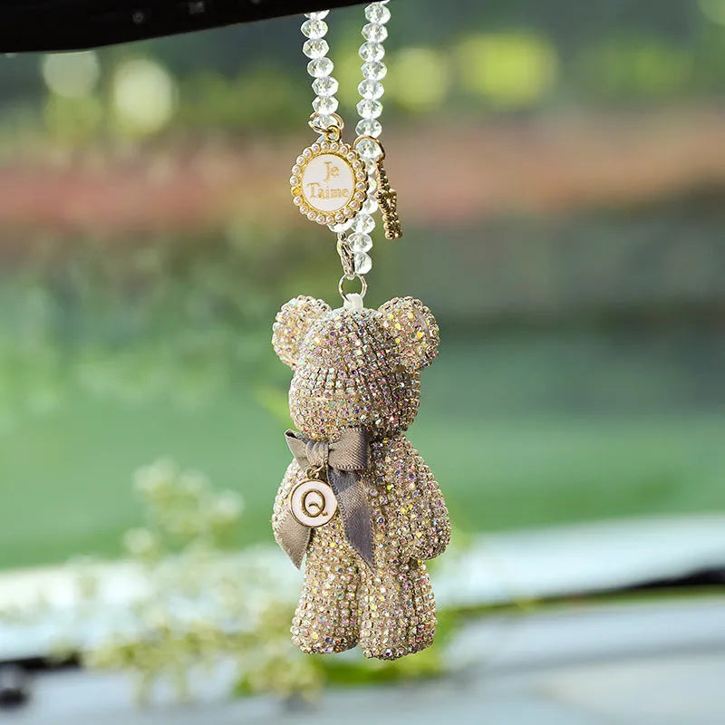 Close-up of a black Violent Bear-shaped car pendant with sparkling rhinestones, hanging from a rearview mirror.