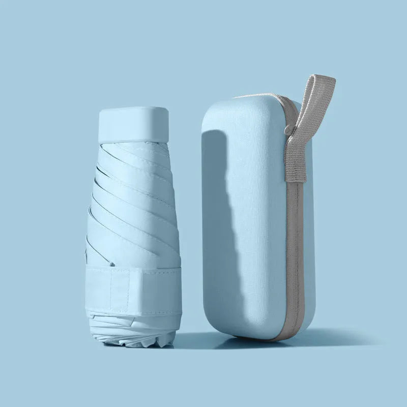 Six-fold manual umbrella in sky blue with capsule box storage, showing compact folded size and rubber handle