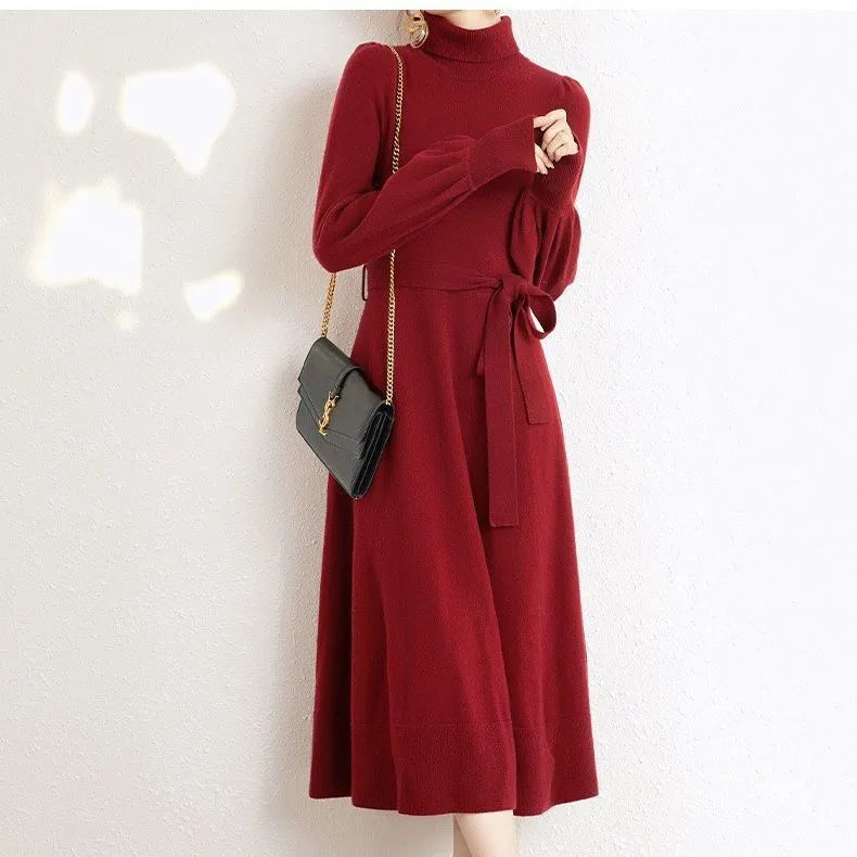 Loose turtleneck knit dress for women with long sleeves, elastic waist, and a big hem in a solid colour.