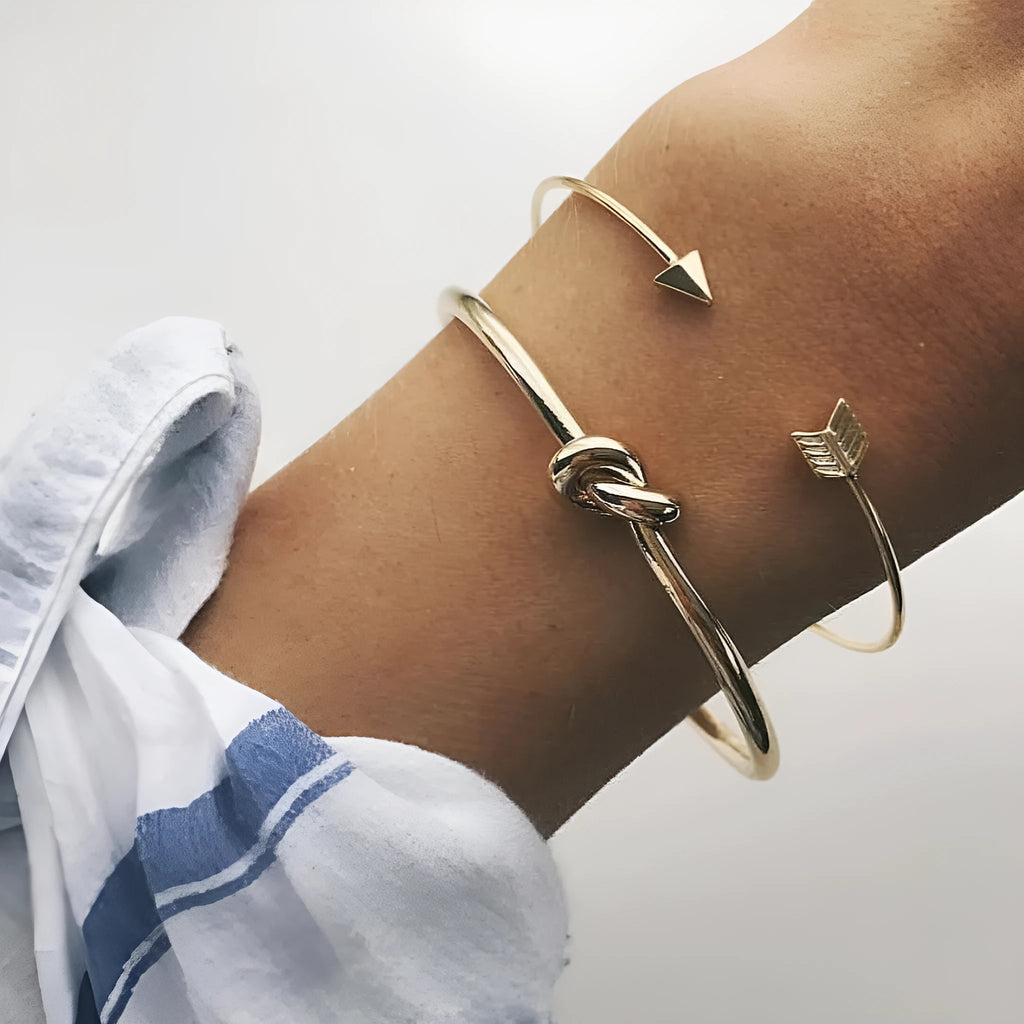 Gold electroplated alloy women's cuff bracelet with arrow and knotted design pattern
