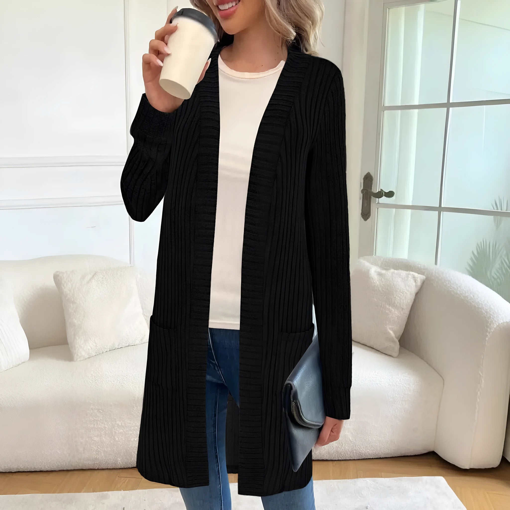 Woman wearing a loose fit, long sleeve, grey knitted cardigan jacket with patch pockets.