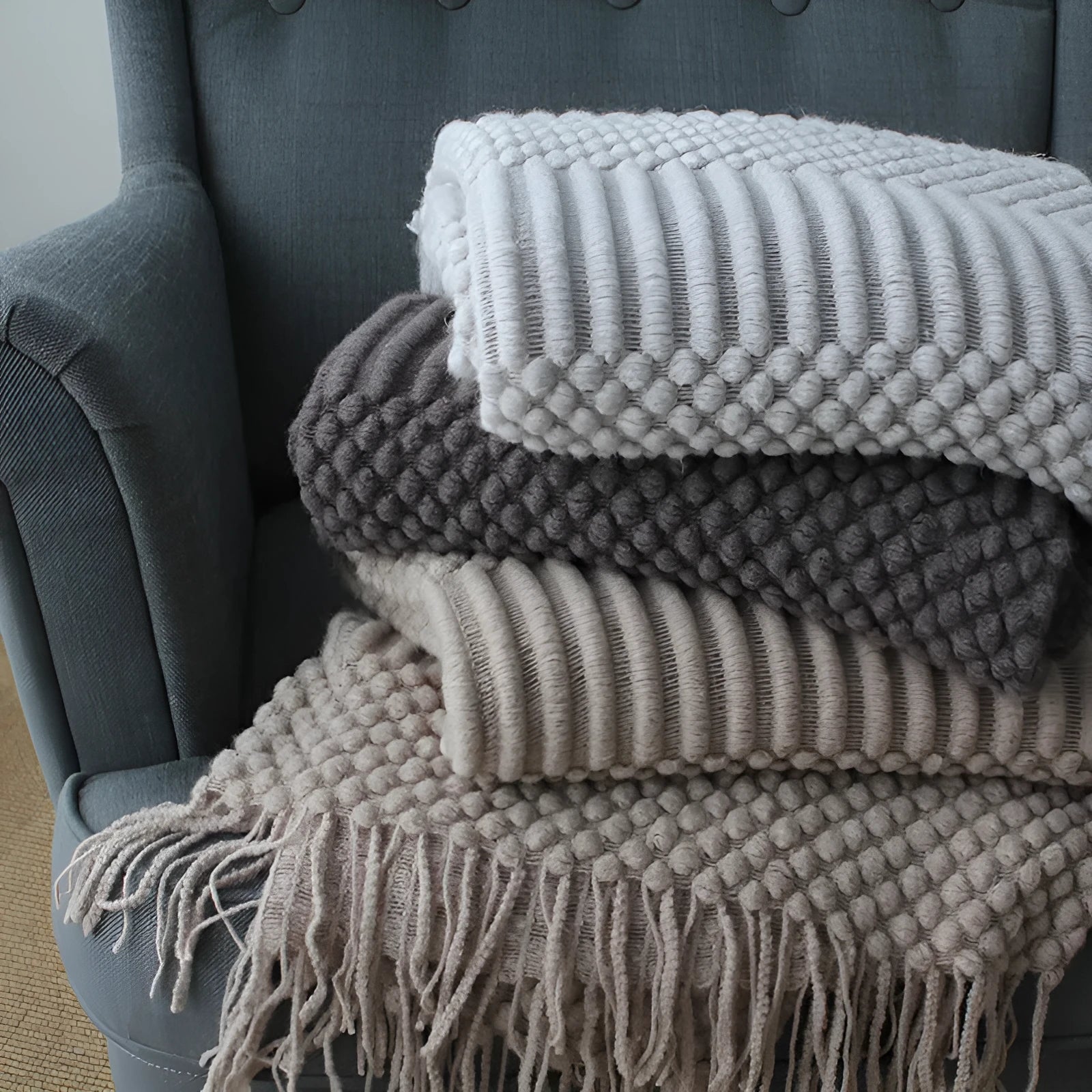 Small grey polyester blanket folded, dimensions 127 by 170 centimetres.