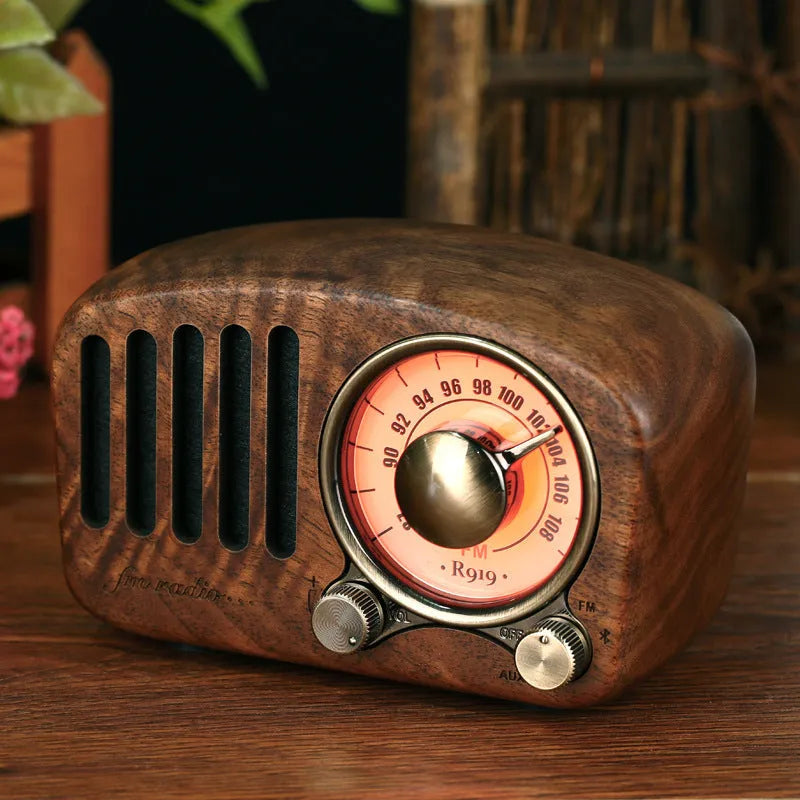 Retro wooden mini Bluetooth speaker in cherry wood finish on a table.