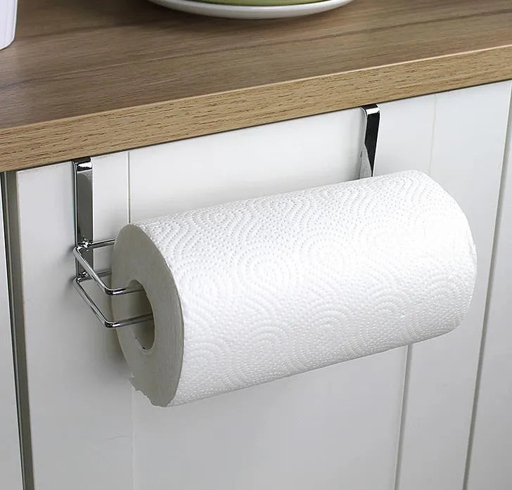 Silver stainless steel paper towel rack hanging on a kitchen cabinet door.