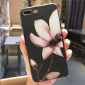 Black TPU iPhone case with a white raised embossed floral pattern on the back.