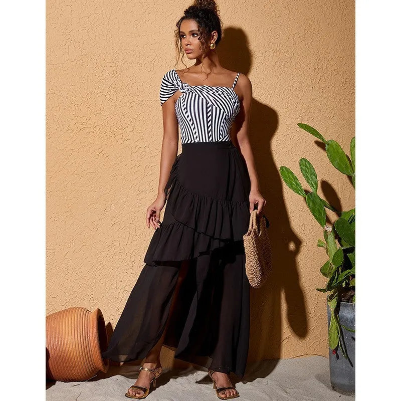Women's black and white striped one-piece swimsuit with a ruffled skirt.