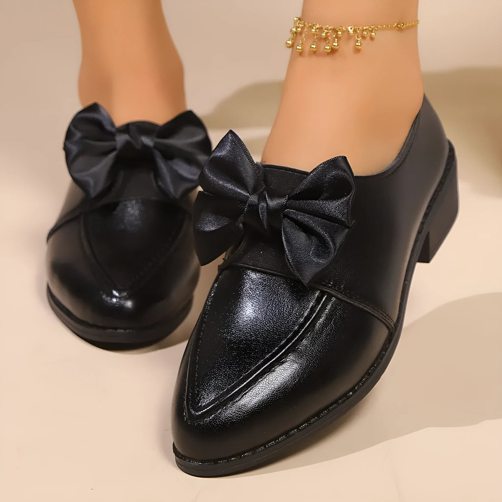 Women's brown PU leather slip-on shoe with a large bow on the pointed toe.
