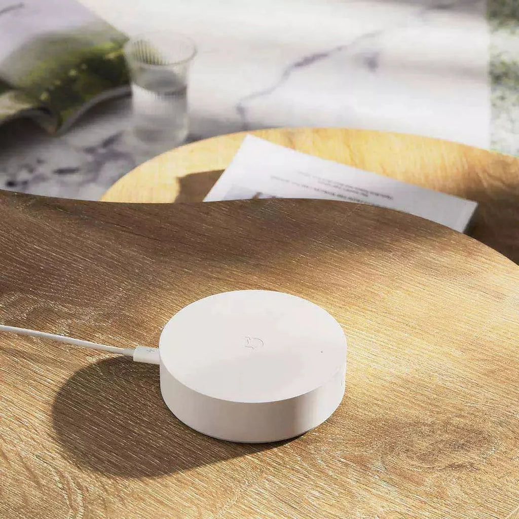 White circular Xiaomi Mijia smart home gateway with UK plug for wireless device control
