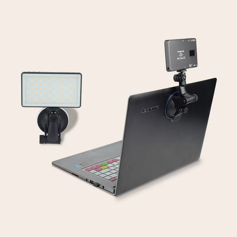 Black aluminium USB LED video conference light with LCD screen, shown next to a laptop