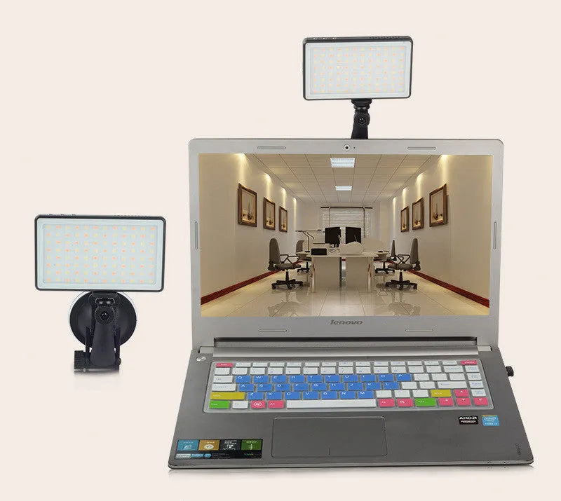 Black aluminium USB LED video conference light with LCD screen, shown next to a laptop