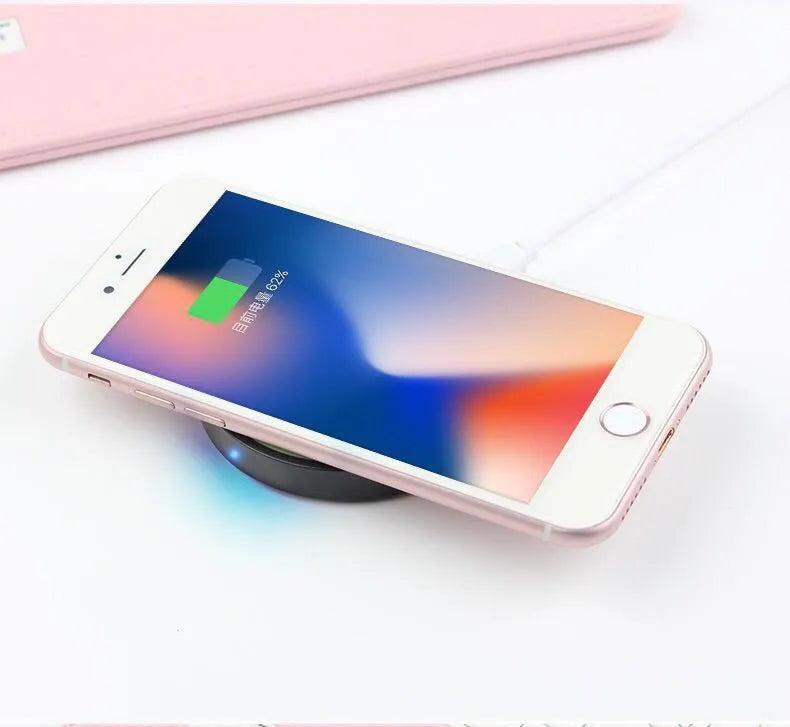 A square, low-profile Qi wireless charging pad in one of six colour options on a table.