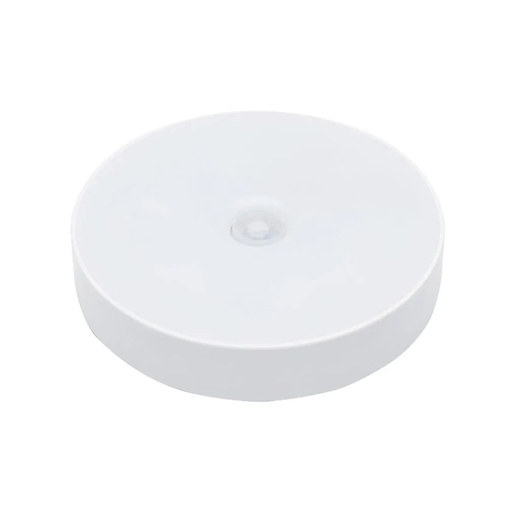 White circular motion sensing night light with USB charging port mounted on wall