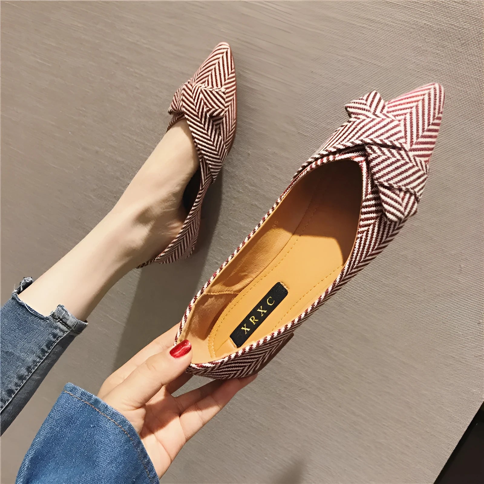 Women's black pointed toe low heel flats with a shallow mouth design on a plain background
