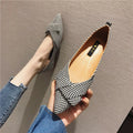 Women's black pointed toe low heel flats with a shallow mouth design on a plain background