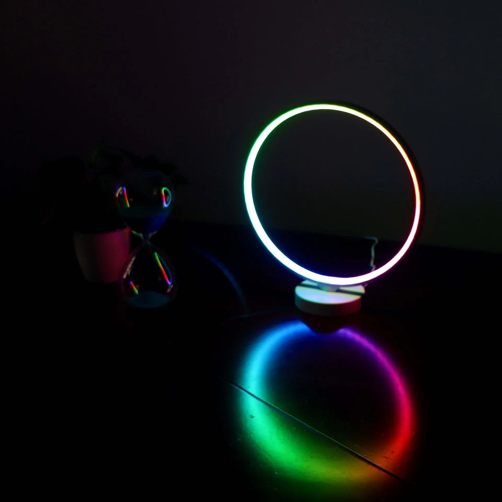 White aluminium and silicone full moon mood lamp with remote control on a table.
