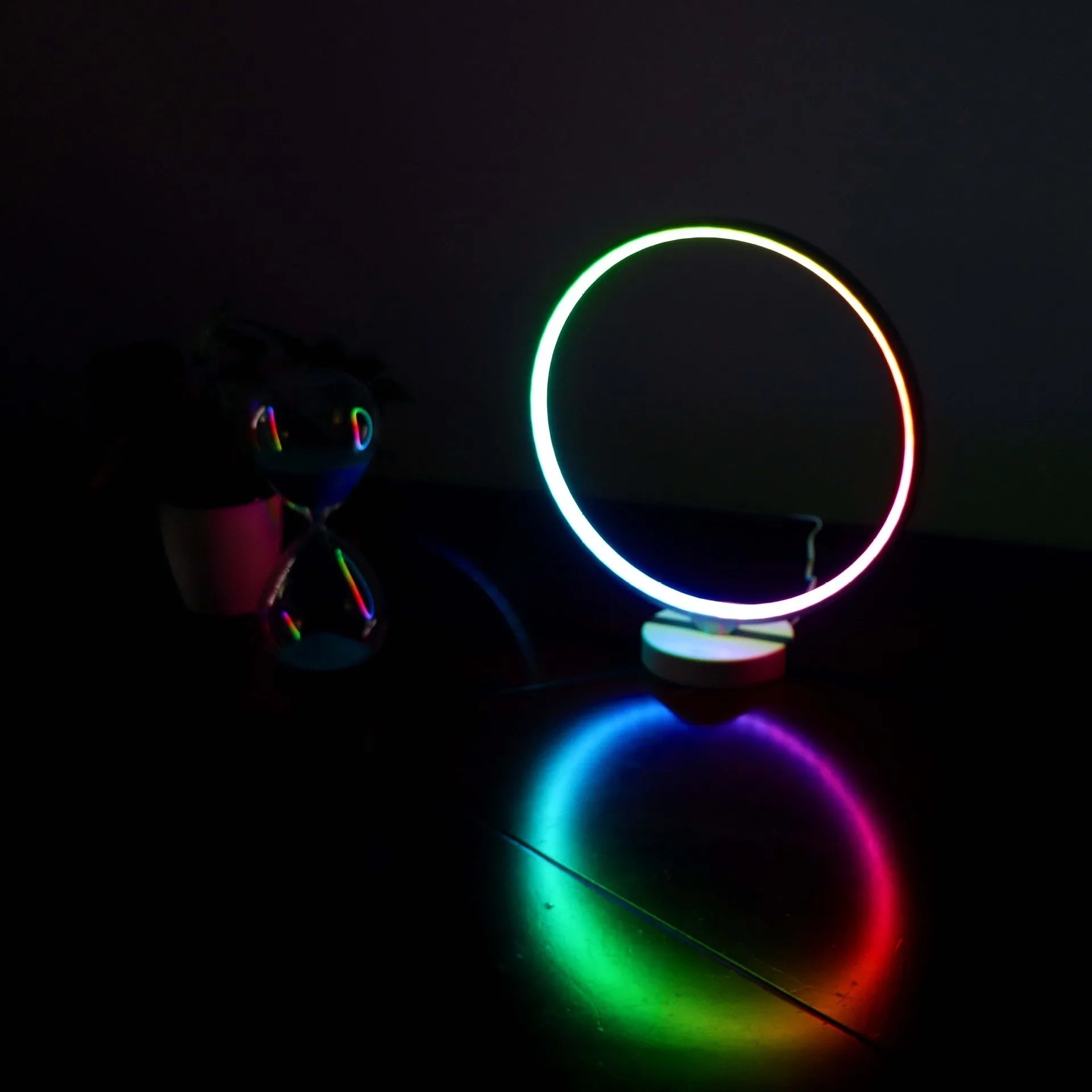 White aluminium and silicone full moon mood lamp with remote control on a table.