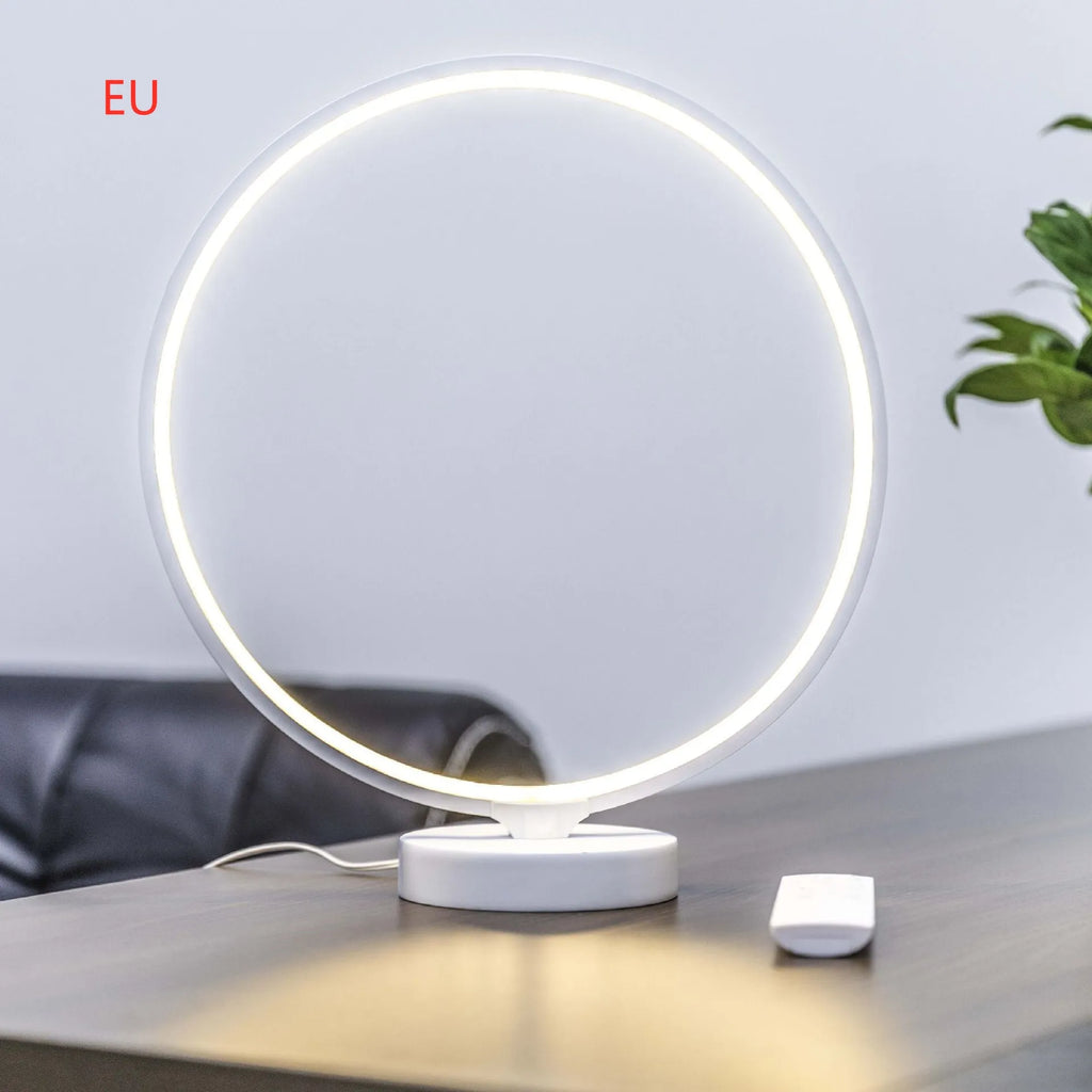 White aluminium and silicone full moon mood lamp with remote control on a table.