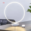 White aluminium and silicone full moon mood lamp with remote control on a table.