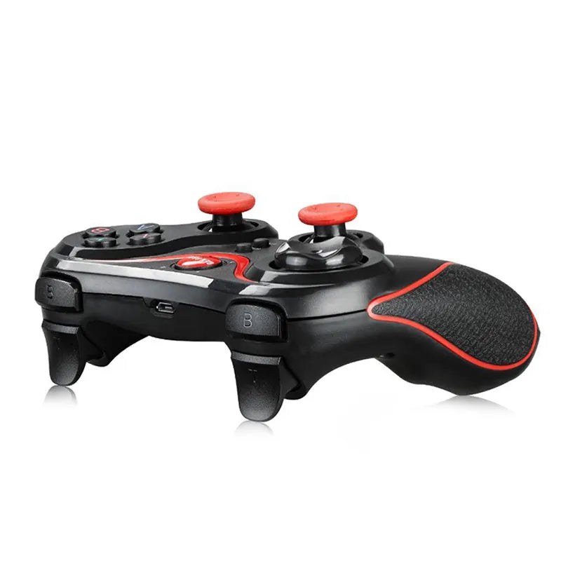 Black wireless Bluetooth gamepad controller for mobile phones on a table next to a charging cable.