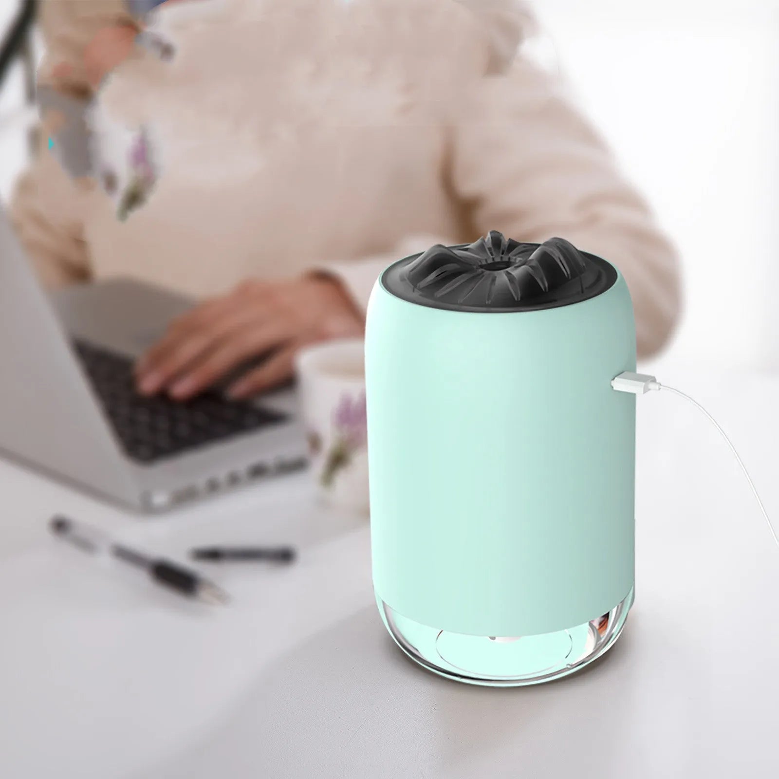 White columnar Magic Flame ultrasonic humidifier with USB cable and water tank on a wooden desk.