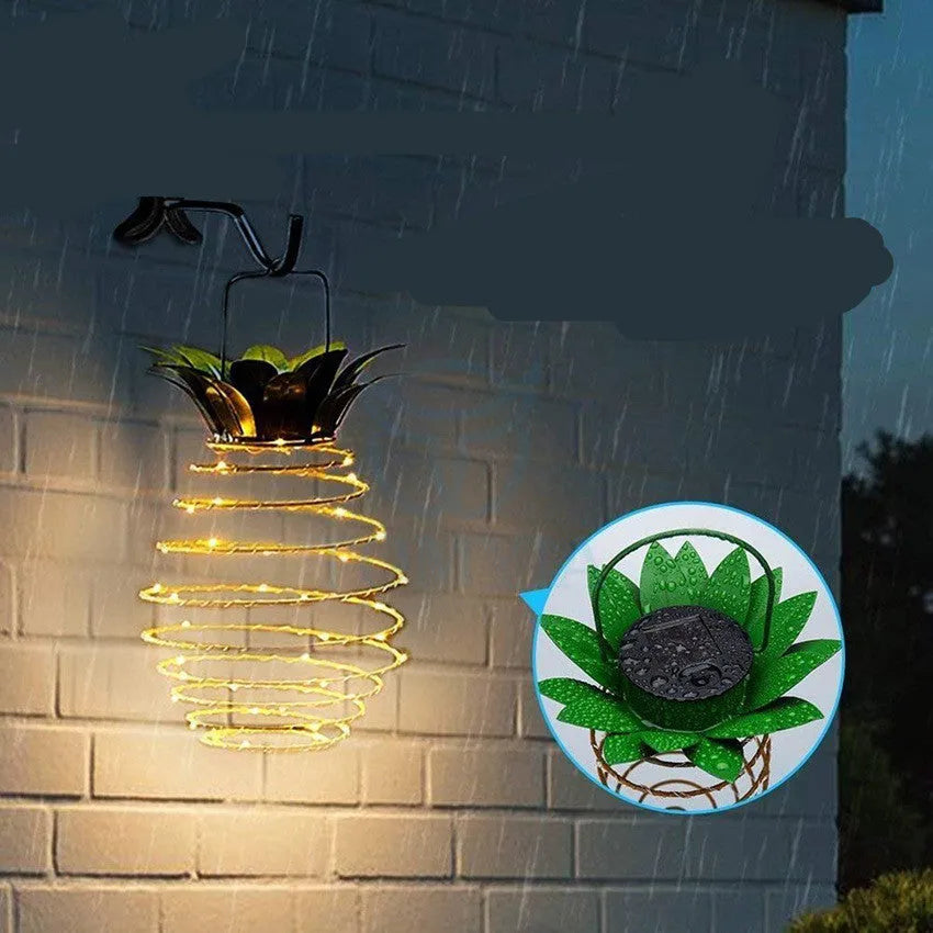 Outdoor waterproof green pineapple solar path light with 20 warm white LEDs and metal frame on a garden table