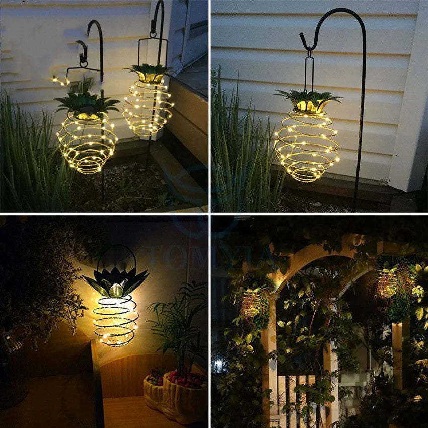 Outdoor waterproof green pineapple solar path light with 20 warm white LEDs and metal frame on a garden table
