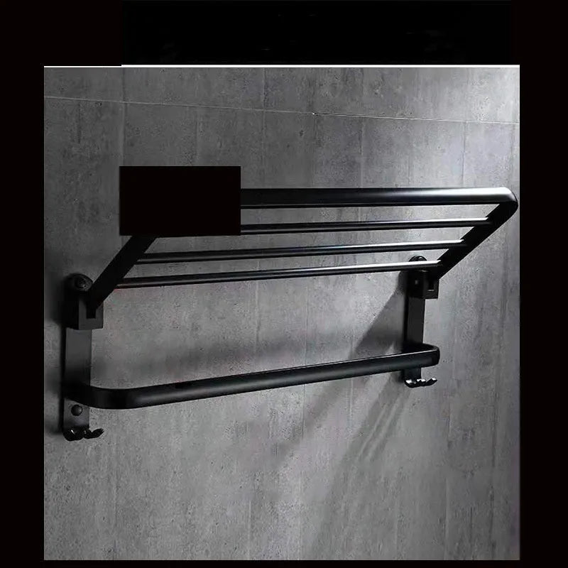 Silver aluminium double-layer folding towel rack with perforated shelf mounted on a bathroom wall.