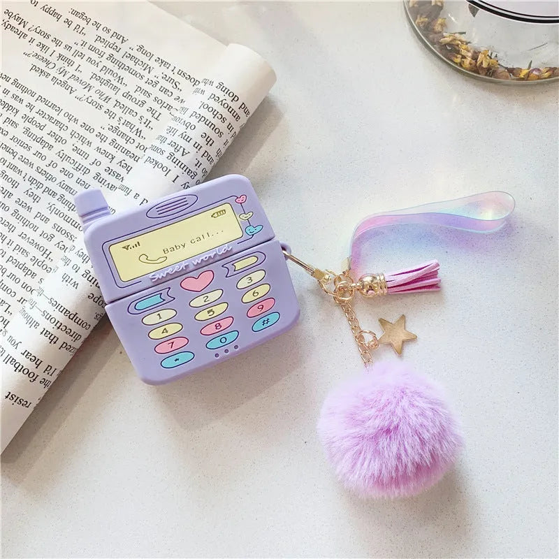 Purple silicone Apple AirPods protective case with attached fur ball pendant on white background