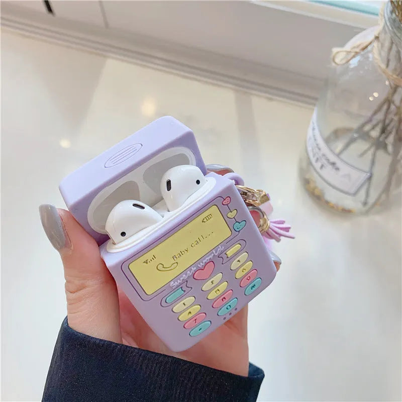 Purple silicone Apple AirPods protective case with attached fur ball pendant on white background