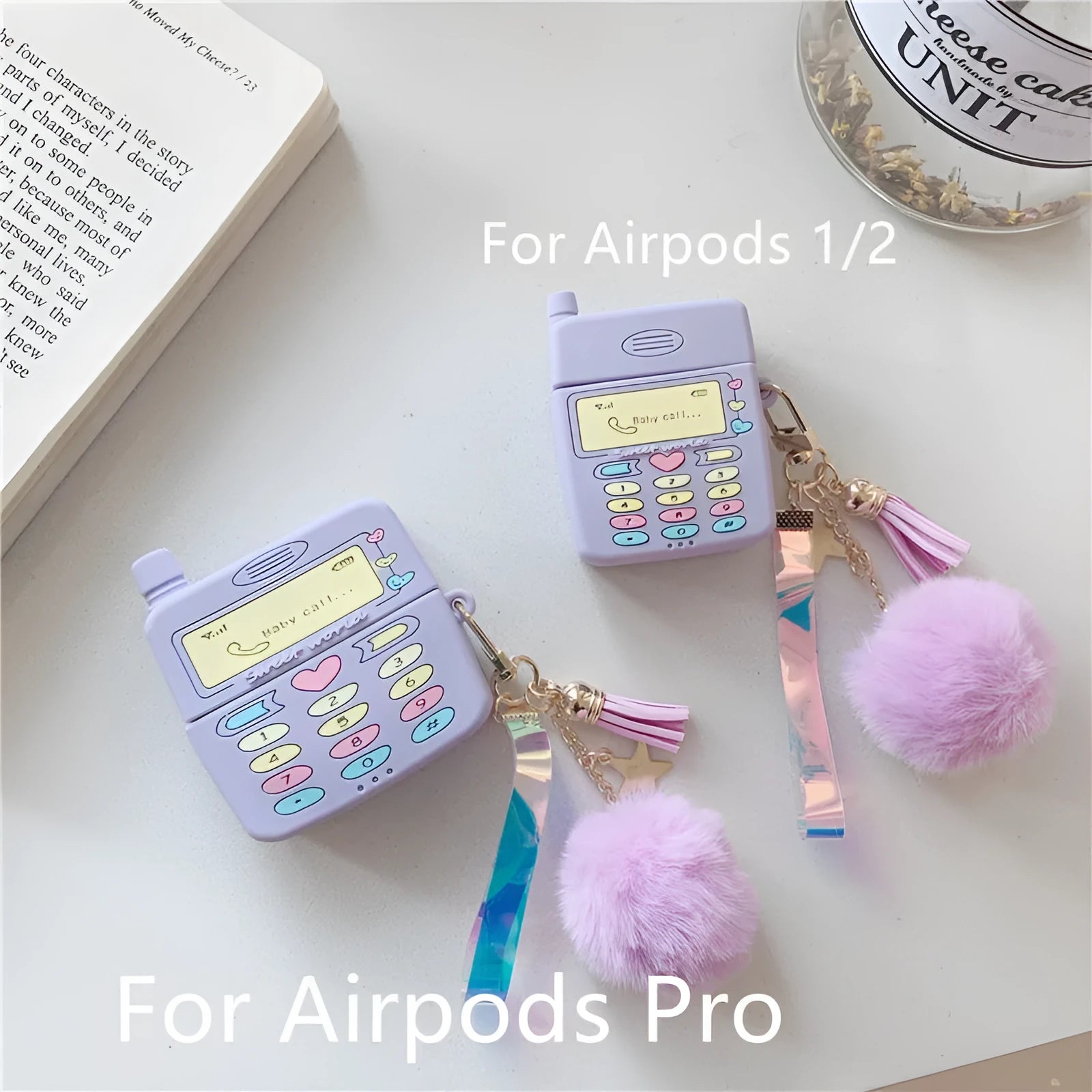 Purple silicone Apple AirPods protective case with attached fur ball pendant on white background