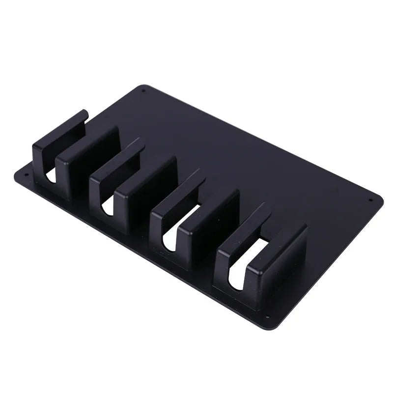 Black plastic wall-mounted rack holding four electric hair clippers for salon or home storage