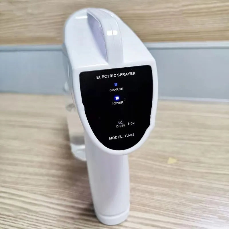 White handheld cordless electric spray disinfection gun with USB charging port.