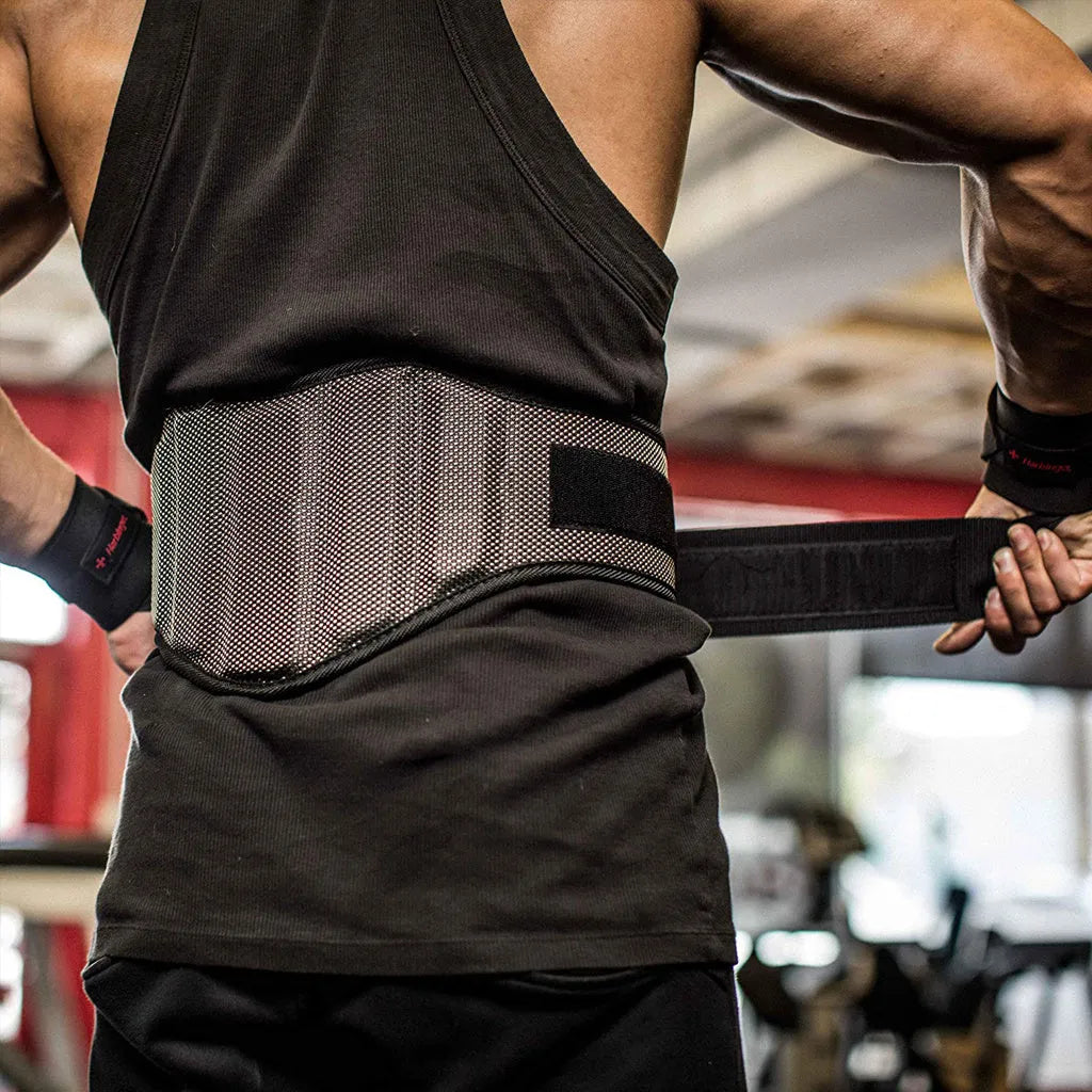 Black nylon squat weightlifting belt with adjustable fastening on a gym floor