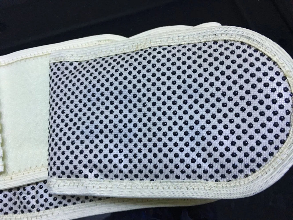 Beige self-heating magnetic waist support belt for lumbar muscle strain on a neutral background.