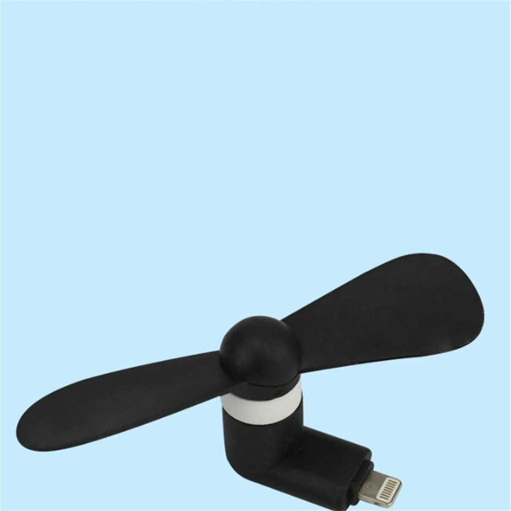 White USB-powered mini personal fan with round plastic blades and a rotary switch, shown next to a mobile phone.