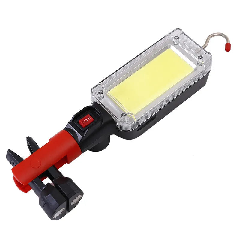 Red portable COB LED flashlight with USB cable and magnetic hook on metal surface