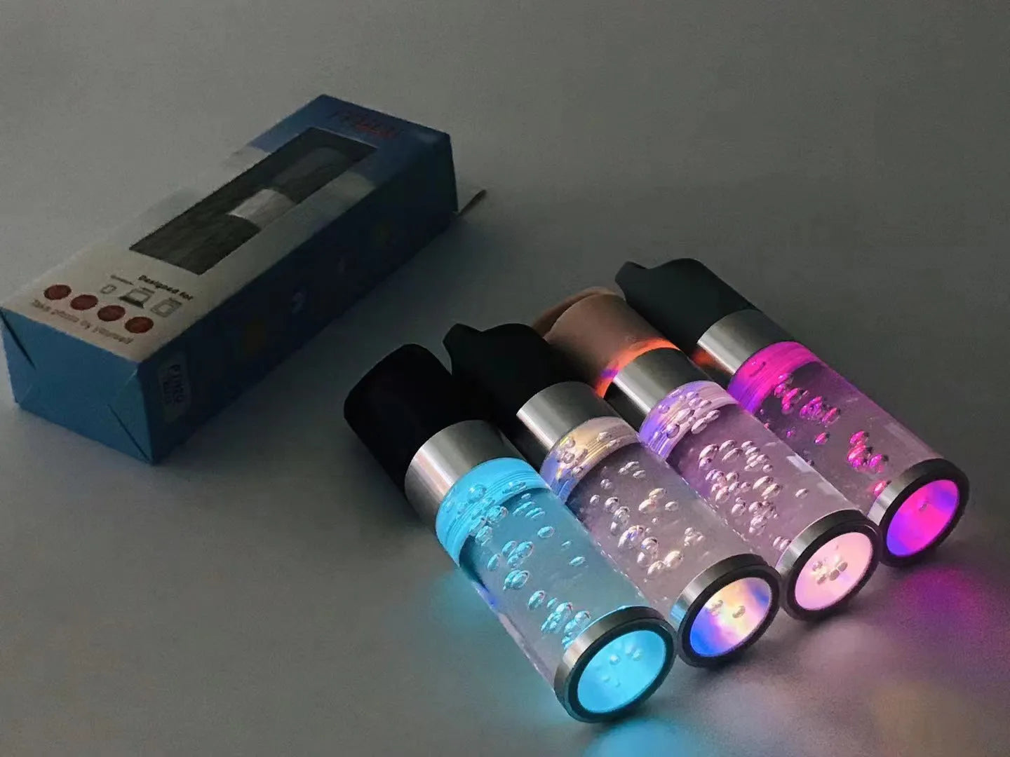 Compact pink portable Bluetooth speaker with colourful crystal light effect on a surface.