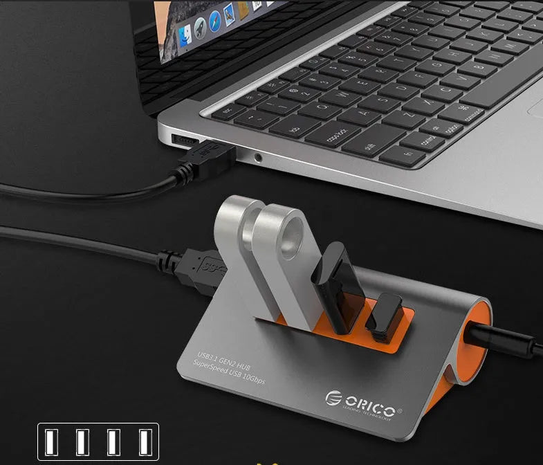 Dark grey aluminium USB hub with four USB 3.1 ports and orange accents, shown with a 100cm data cable.