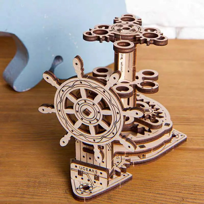 Wooden desk model with a steering wheel that rotates a platform holding pens and pencils.