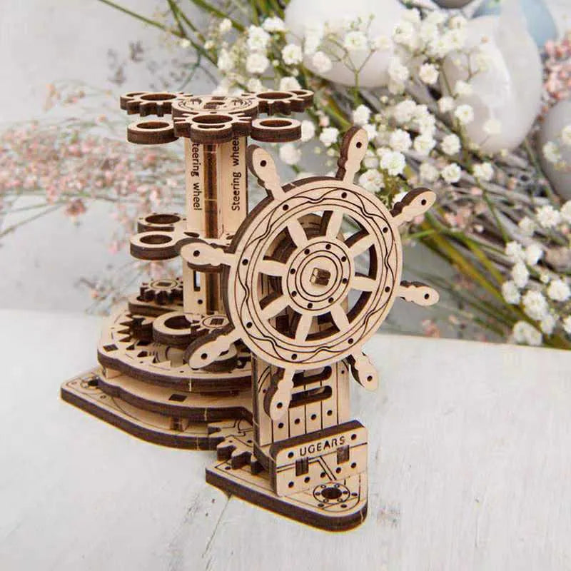 Wooden desk model with a steering wheel that rotates a platform holding pens and pencils.