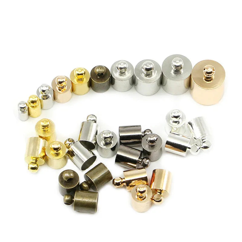 Assortment of electroplated copper bell-shaped tassel caps in various colours and sizes for jewellery making.