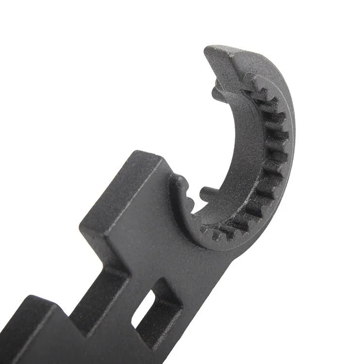 Black all-steel combination wrench for AR15 and M4 rifle maintenance on a workshop bench.