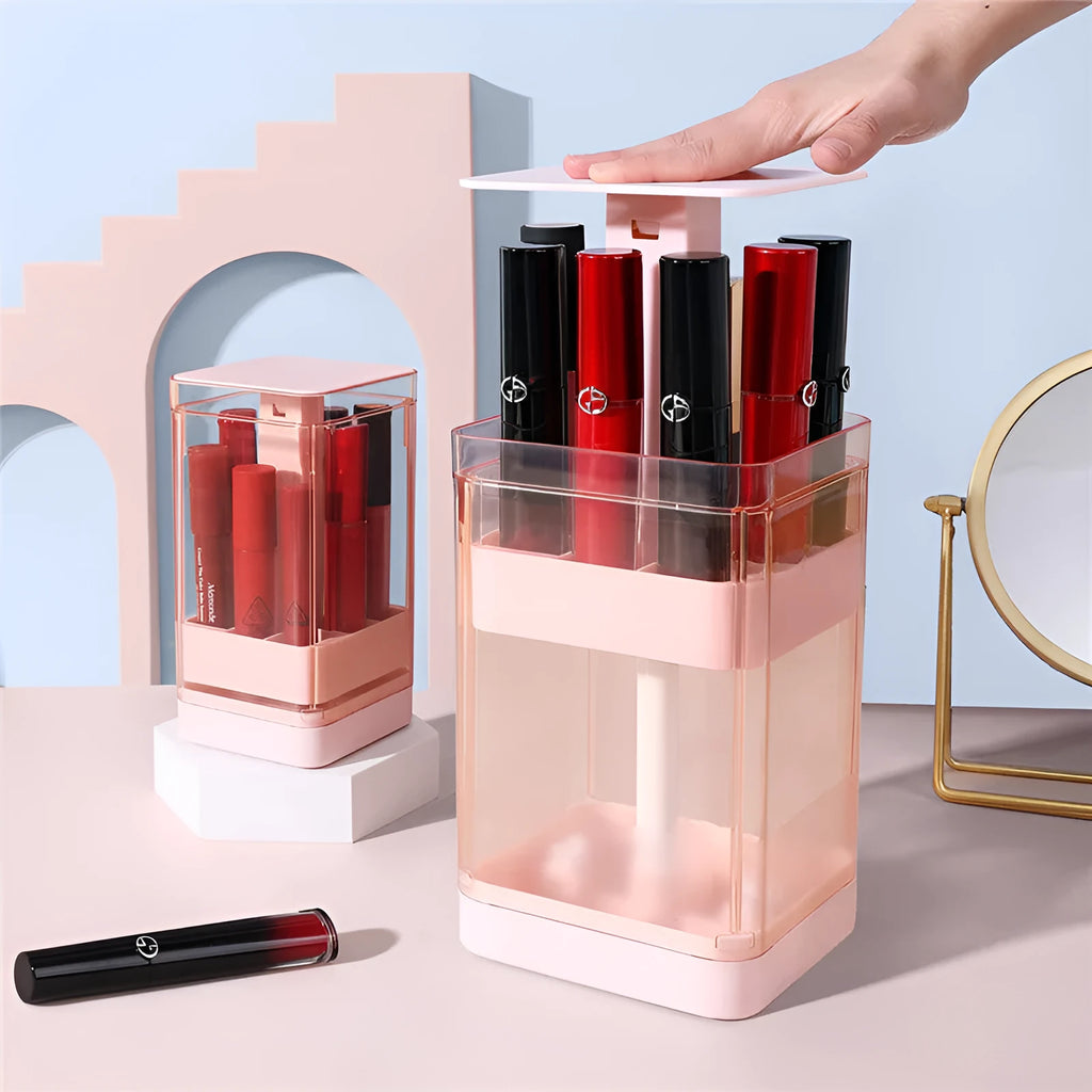 White press-lift lipstick storage box with dust cover on a desktop, showing open 12-grid compartments.