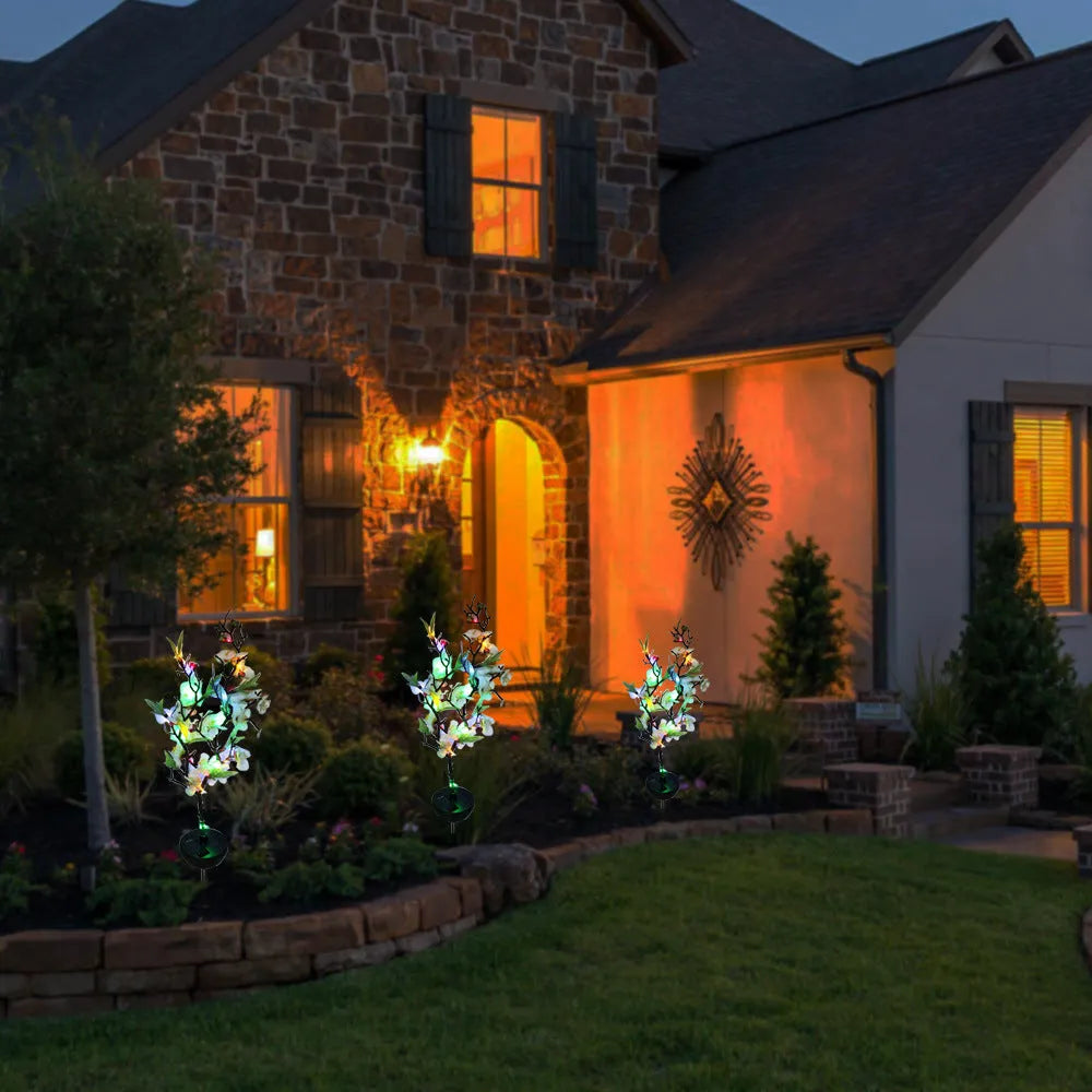 Solar-powered cherry firework string outdoor light with metal ground spike on a lawn.