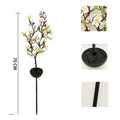 Solar-powered cherry firework string outdoor light with metal ground spike on a lawn.