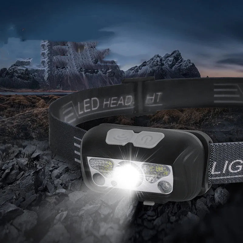 Black outdoor headlamp with adjustable strap, showing white and red LED lights and a micro USB charging port.