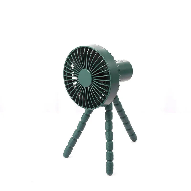 Compact USB desktop fan with flexible black tripod legs and a white fan head on a wooden desk.