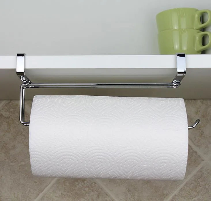 Silver stainless steel paper towel rack hanging on a kitchen cabinet door.