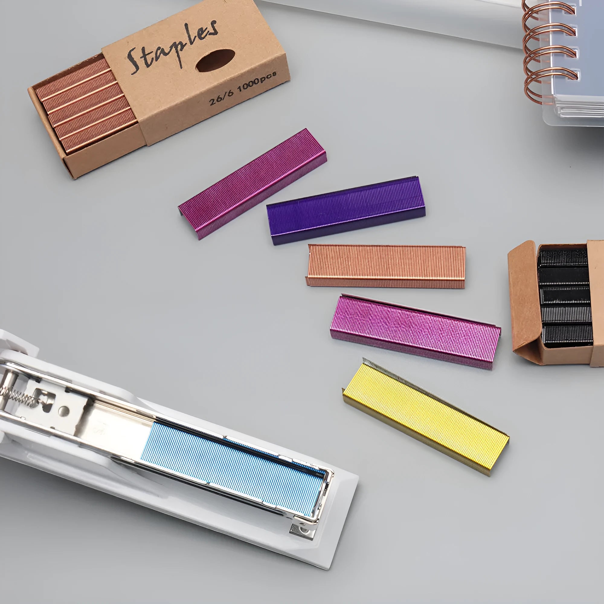 A box of 1000 metal office staples in colours black, purple, rose gold, and rose red.