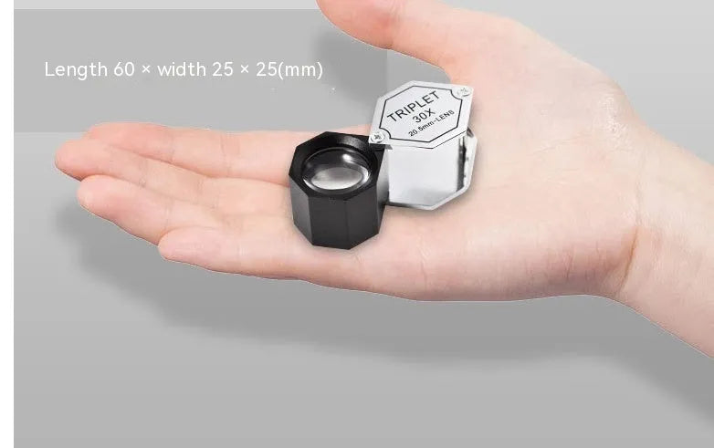 Handheld metal magnifying glass with optical glass lens for jewellery and stamp inspection.